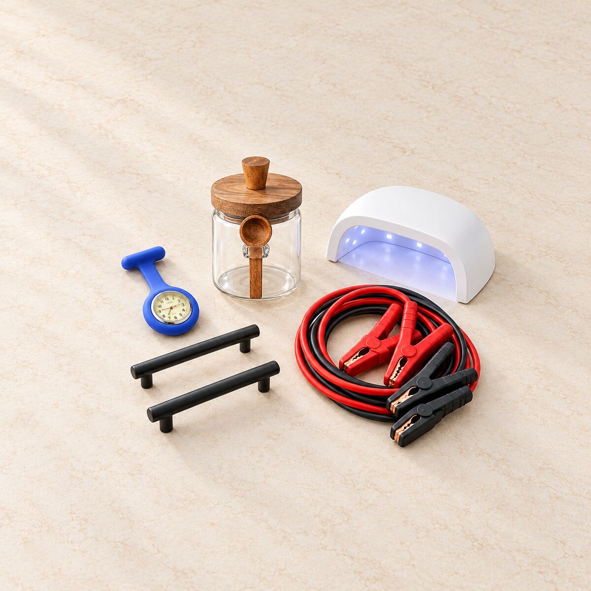 Tidy product flat lay: fob watch, glass jar, cabinet handles, jumper leads, nail lamp.
