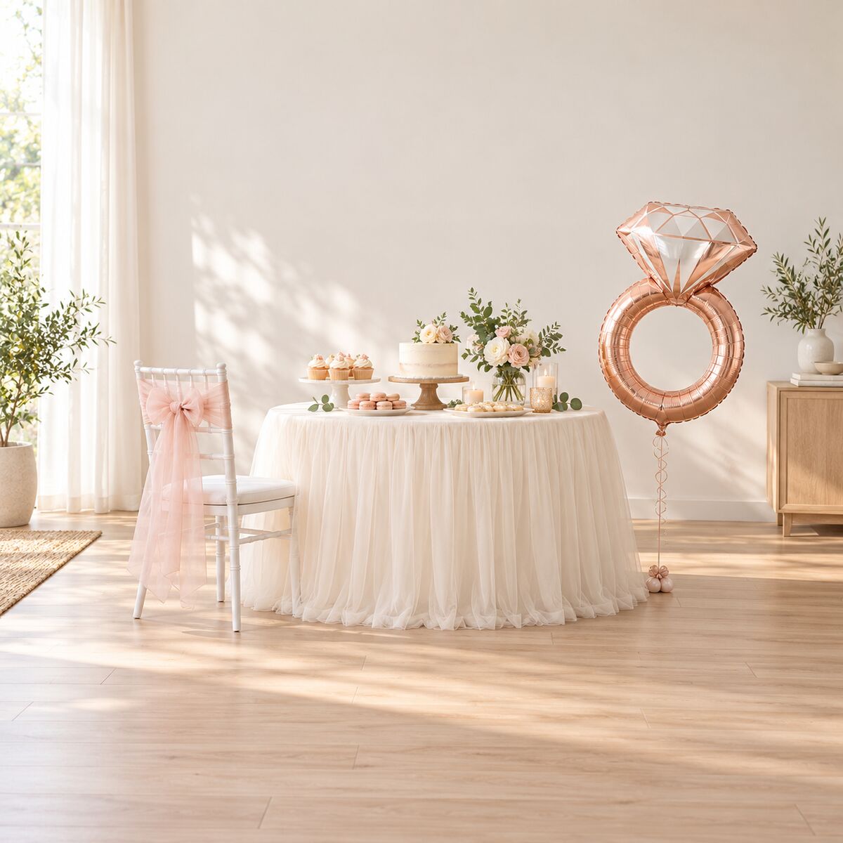 Tulle table skirt on a dessert table, organza chair sashes, rose-gold foil balloon.
