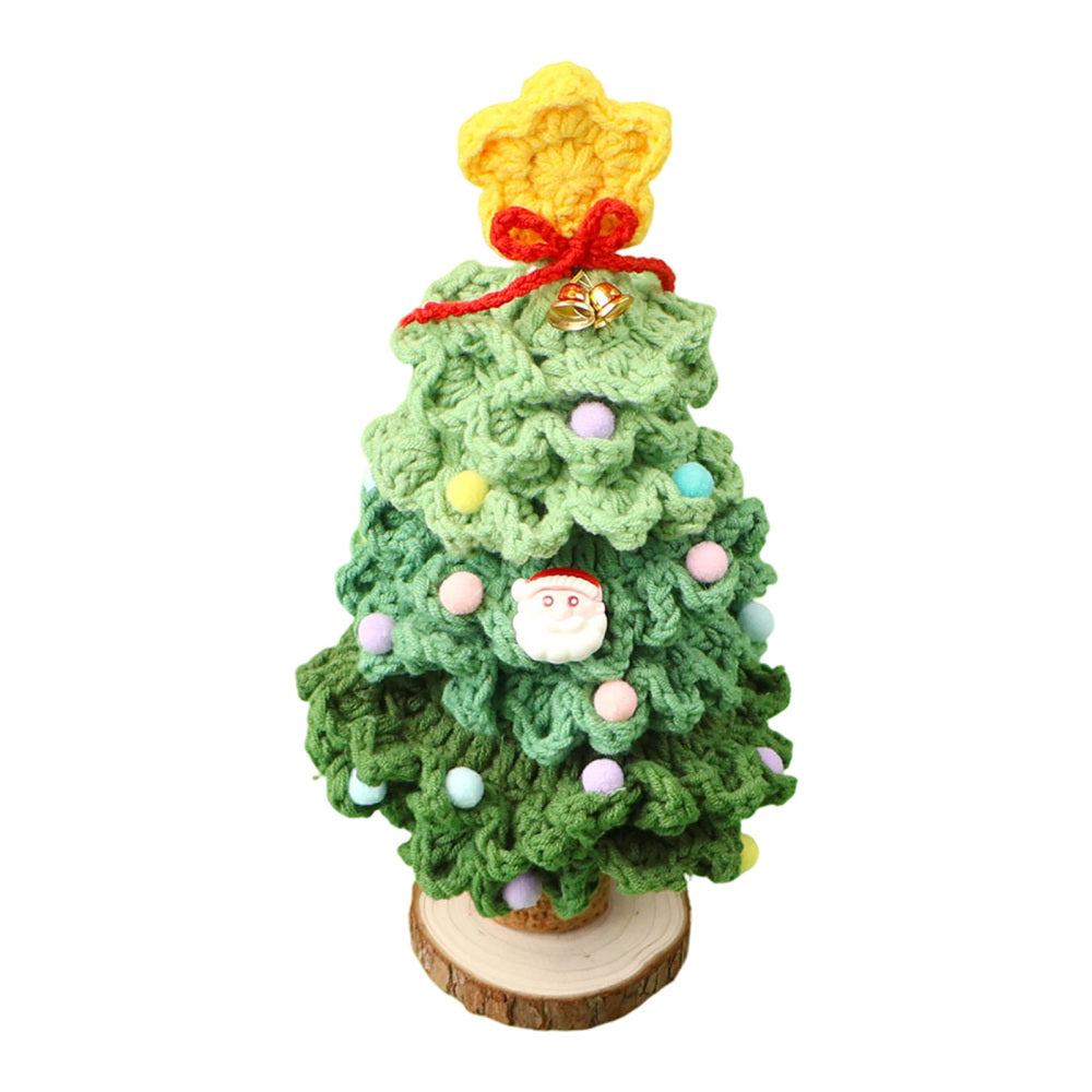 Dark green hand-crocheted tabletop Christmas tree with pom-poms on wooden base