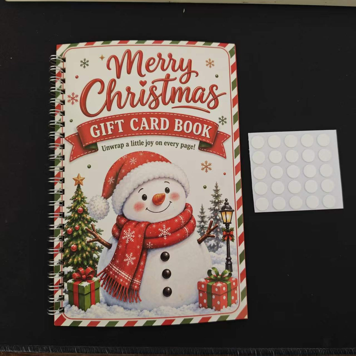 Snowman Christmas gift card book cover on dark table with adhesive dots