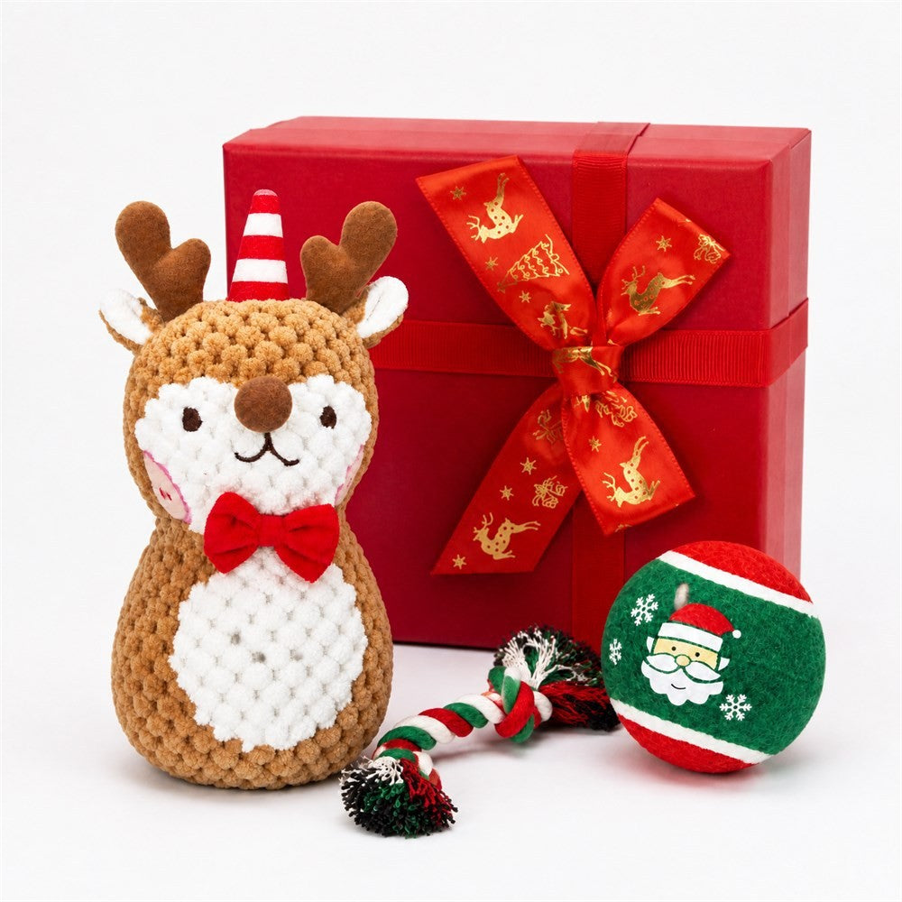 Plush reindeer dog toy with rope tug and Santa ball beside red ribbon gift box
