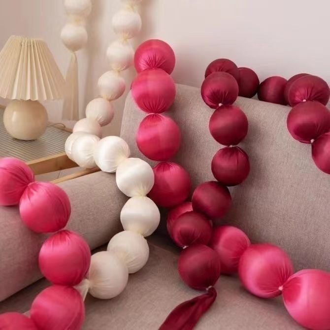 Pink and white ball garlands on a sofa