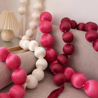 Pink and white ball garlands on a sofa