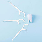 White floss picks with a tooth model
