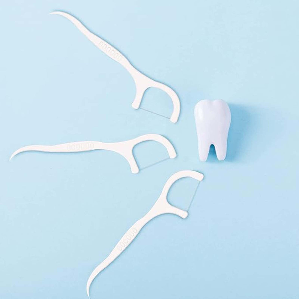 White floss picks with a tooth model