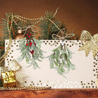 Two artificial mistletoe picks on a festive gold-decorated board with baubles