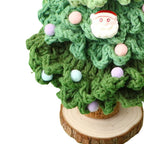 Close-up of dark green crochet Christmas tree stitches with Santa charm