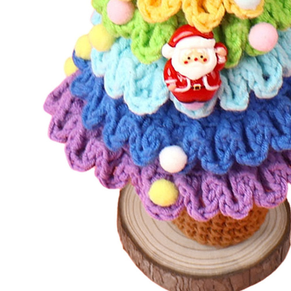 Close-up of crochet Christmas tree tiers with Santa face charm and pom-pom baubles