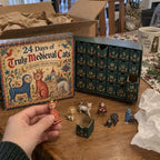 Hand holding a small cat figurine from the medieval cat advent calendar