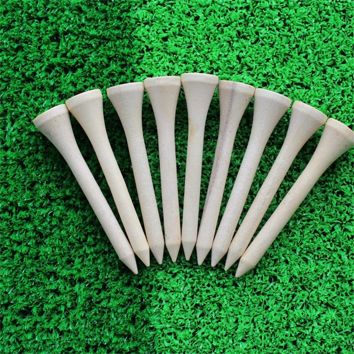 Wooden golf tees standing on green grass
