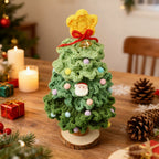 Dark green crochet mini Christmas tree on wooden table with pine cones and candles