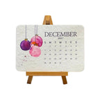 Plantable December 2027 calendar card displayed on small wooden easel