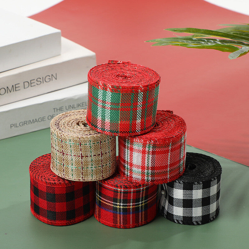Assorted wired Christmas ribbon rolls stacked on a desk – tartan, plaid and gingham