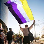 Non binary flag held outdoors at an event