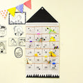 Black roof fabric advent calendar with filled pockets on a wall