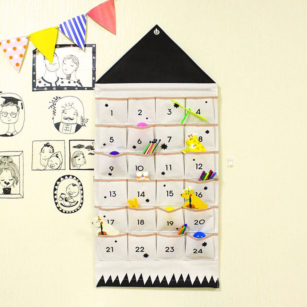 Black roof fabric advent calendar with filled pockets on a wall